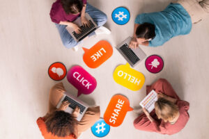 Social Media Marketing - četvoro mladih okupljeni na podu sa laptopima