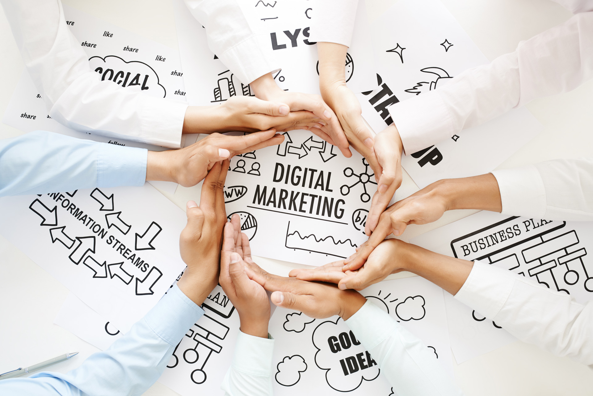 Najčešće pogreške u digitalnom marketingu i kako ih izbjeći - ruke suradnika koje formiraju krug oko postavljenog papira na stolu sa natpisom Digital Marketing